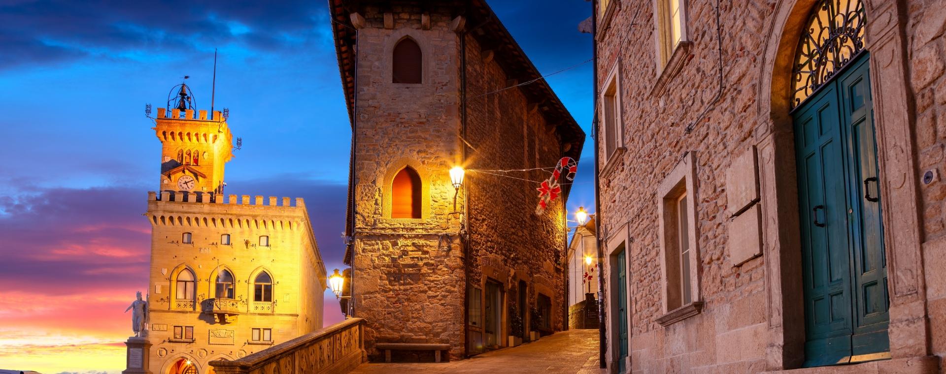 Vista serale di un edificio storico illuminato con cielo al tramonto.
