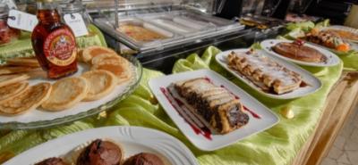 Buffet di dolci con pancake, sciroppo d'acero e dolci al cioccolato.