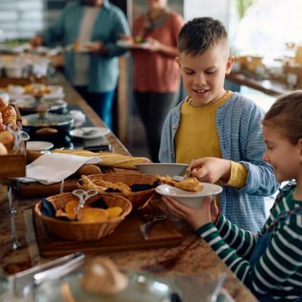 Bambini scelgono pane e dolci da un buffet ricco di opzioni deliziose.